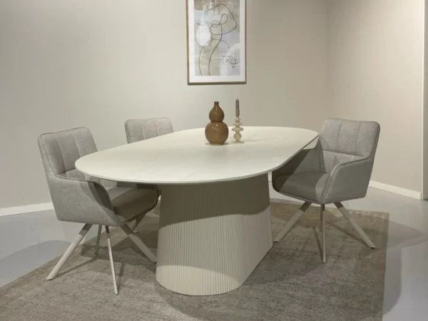 Beige dining table with chic, stylish look. This trendy table features a rounded top, trendy design, tapered leg.